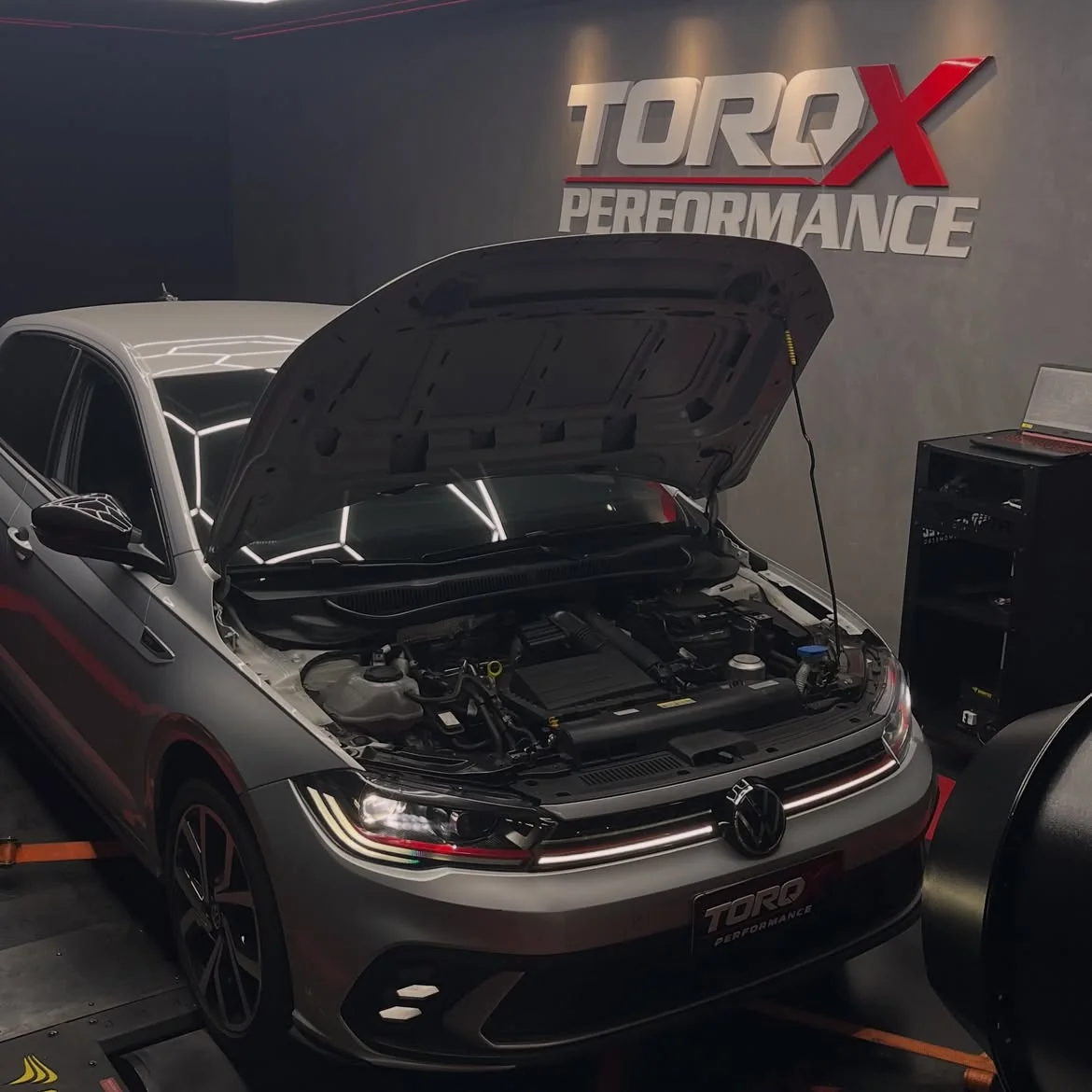 Volkswagen Polo GTS cinza com o capô levantado no leito do dinamômetro, com o ventilador de refrigeração à direita